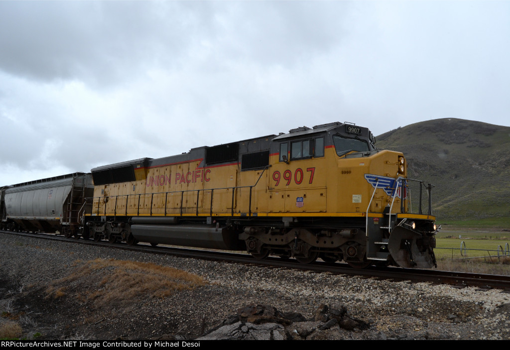 UP SD59MX #9907 leads the Cache Valley Local (LCG-41E) approaching the 4800 W. 900N. grade xing in Trenton, Utah. April 15, 2022